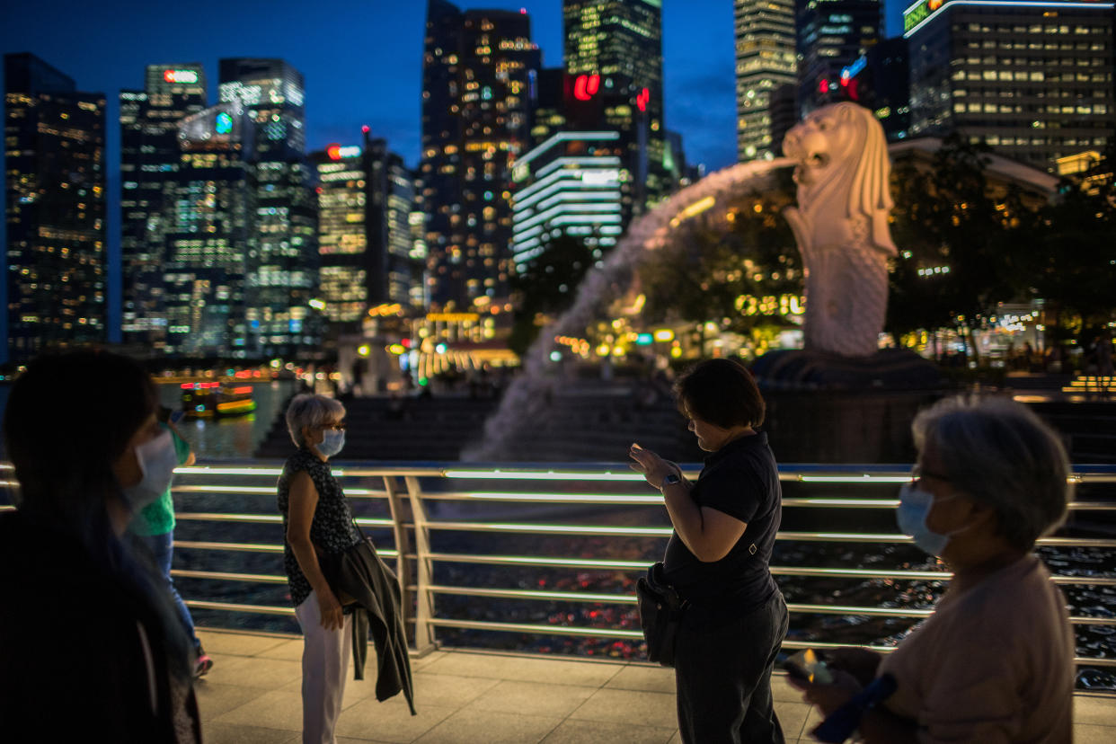 SINGAPORE - 2020/02/12: People wearing protective surgical masks visit the Merlion Park, a major tourist attraction in Singapore. Singapore declared the Coronavirus outbreak alert as Code Orange on February 7, 2020. (Photo by Maverick Asio/SOPA Images/LightRocket via Getty Images)