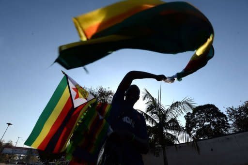 A vendor sells flags on a street in Harare on August 21, 2013, the eve of President Mugabe's inauguration ceremony. Zimbabwe's veteran leader Robert Mugabe will host a massive stadium-filling presidential inauguration to usher in a new five year term Thursday, despite expected limited attendance by foreign leaders and a boycott by his election rival