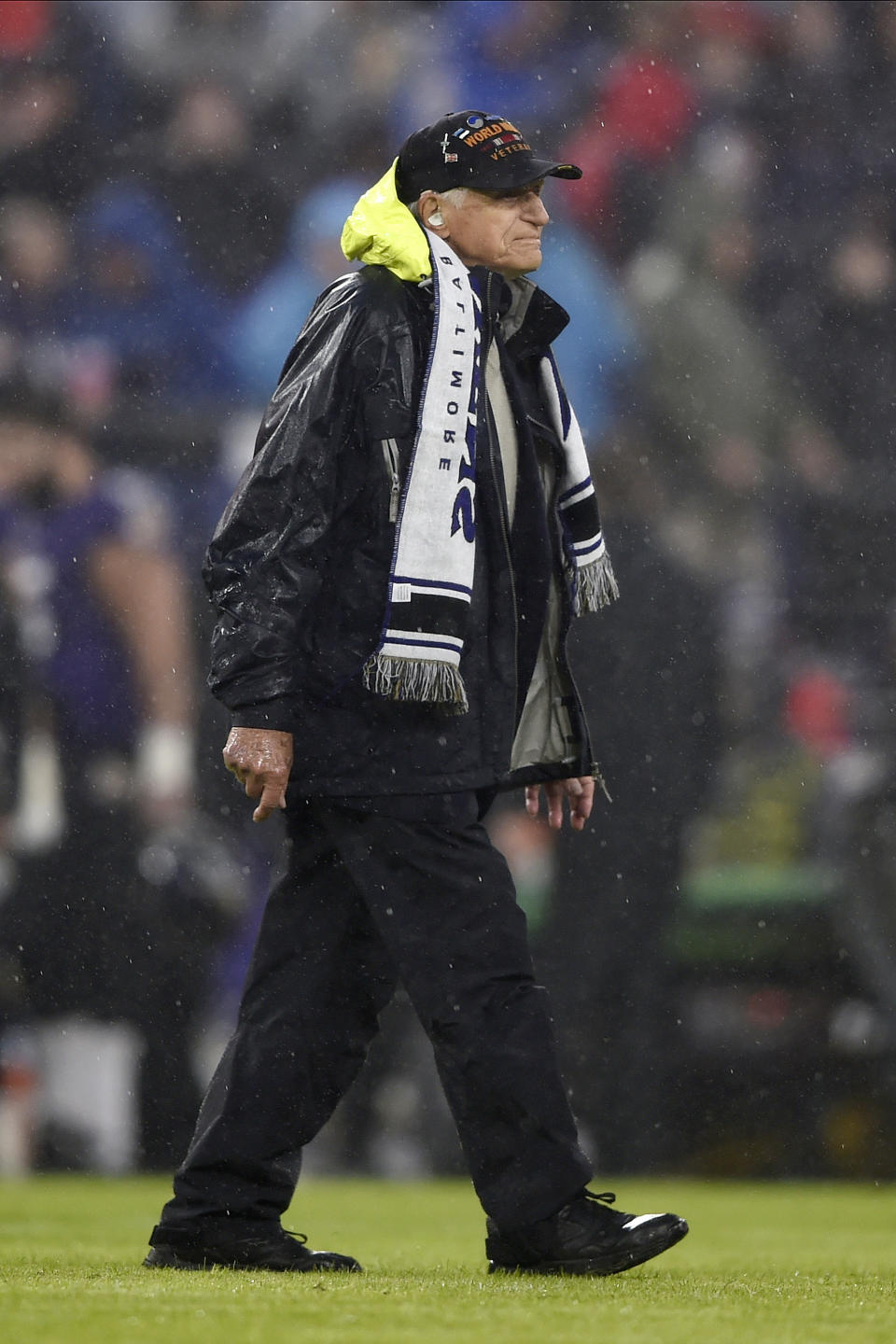 Steve Melnikoff, 100, who fought in World War II and took part in D-Day, walks on the field at M&T Bank Stadium while serving as the Ravens' honorary captain prior to an NFL football game between the Baltimore Ravens and the Pittsburgh Steelers, Sunday, Dec. 29, 2019, in Baltimore. (AP Photo/Gail Burton)