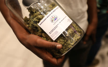 A man holds a jar full of cannabis buds before they were handed out by activist Steven Thapelo Khundu at the expo entrance, encouraging attendees to bring them inside, during the opening of the four-day expo in Pretoria, South Africa, December 13, 2018. REUTERS Siphiwe Sibeko
