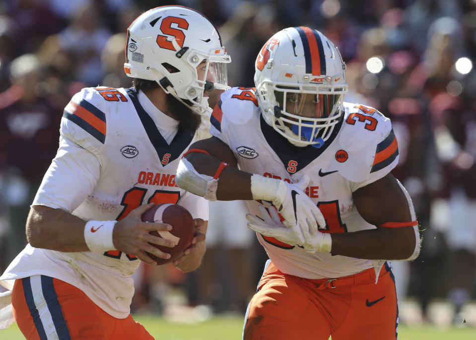 Syracuse quarterback Garrett Shrader (16) fakes a handoff to Syracuse running back Sean Tucker (34) in the second half of the Syracuse Virginia Tech NCAA football game in Blacksburg Va. Saturday Oct. 23 2021. (Matt Gentry/The Roanoke Times via AP)