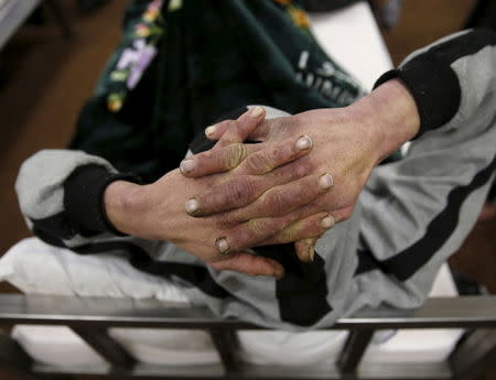 A drug addict holds his head as he sits on his bed at a newly-opened treatment centre at Camp Phoenix, in Kabul, Afghanistan January 3, 2016. REUTERS/Ahmad Masood