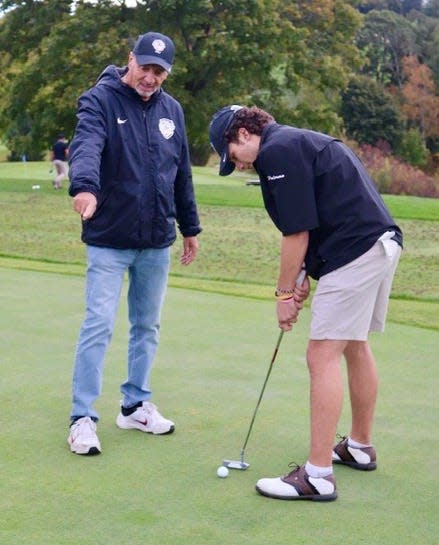 St. Paul golf coach Rob Riggieri offers putting tips for senior Chris Palermo.