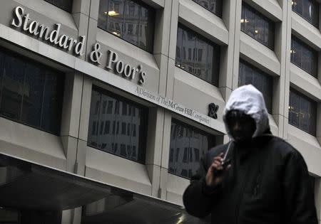 A man walks past the Standard & Poor's building in New York's financial district February 5, 2013. REUTERS/Brendan McDermid