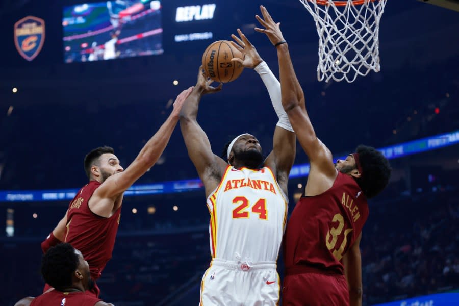 Atlanta Hawks forward Bruno Fernando (24) goes up for shot against Cleveland Cavaliers’ Jarrett Allen (31) and Max Strus during the first half of an NBA basketball game Saturday, Dec. 16, 2023, in Cleveland. (AP Photo/Ron Schwane)