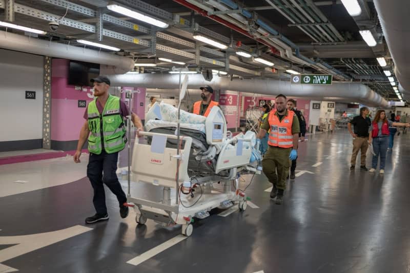 Paramedics assist medical staff at Rambam Hospital in transporting patients from the upper floors to an underground parking area following an attack by the pro-Iranian Hezbollah movement. Ilia Yefimovich/dpa