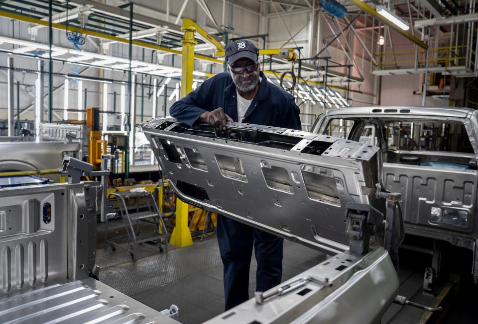 Ford Motor Company inspector Roderick "Treetop" Williams removes a tailgate from a Ford F-150 while doing measurements on the early stages of the vehicle in the Body Shop at the Dearborn Truck Plant in Dearborn on Tuesday, June 6, 2023.