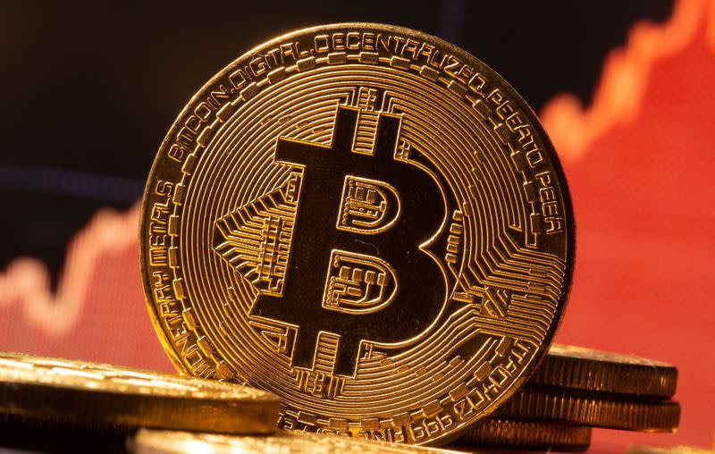 FILE PHOTO: A representation of virtual currency Bitcoin is seen in front of a stock graph