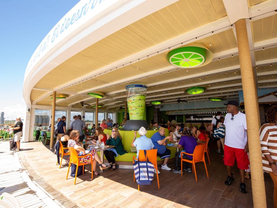 People sitting at tables in an open-aired seating area.