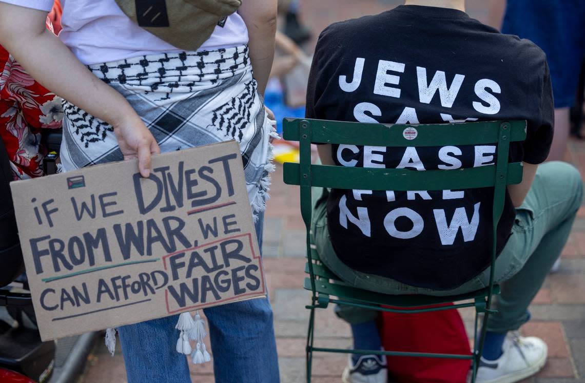 Demonstrators with signs calling for a cease fire in the Israeli Hamas War, divestment from war and fair wages for all during a May Day Rally on the CCB Plaza on Wednesday, May 1, 2024 in Durham, N.C.