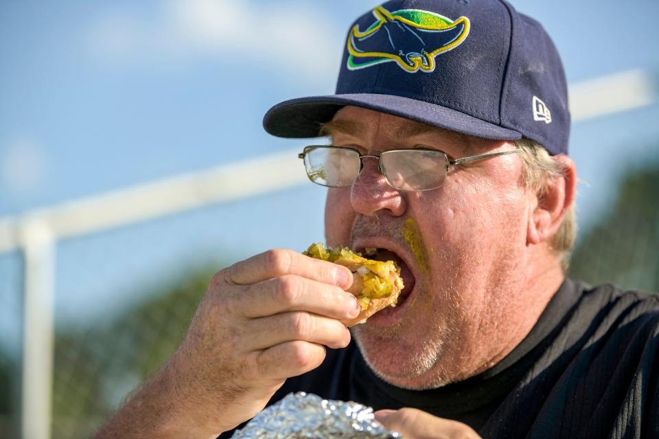 Daily Commercial reporter Frank Jolley eats a sausage dog at a Leesburg Lightning game at Pat Thomas Stadium-Buddy Lowe Field in Leesburg.
