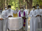 Indian Christian priests offer prayers next to the coffin of Father Rolfie D'Souza's who died of COVID-19, at a cemetery in Prayagraj, India, Saturday, May 15, 2021. India's Prime Minister Narendra Modi on Friday warned people to take extra precautions as the virus was spreading fast in rural areas. (AP Photo/Rajesh Kumar Singh)