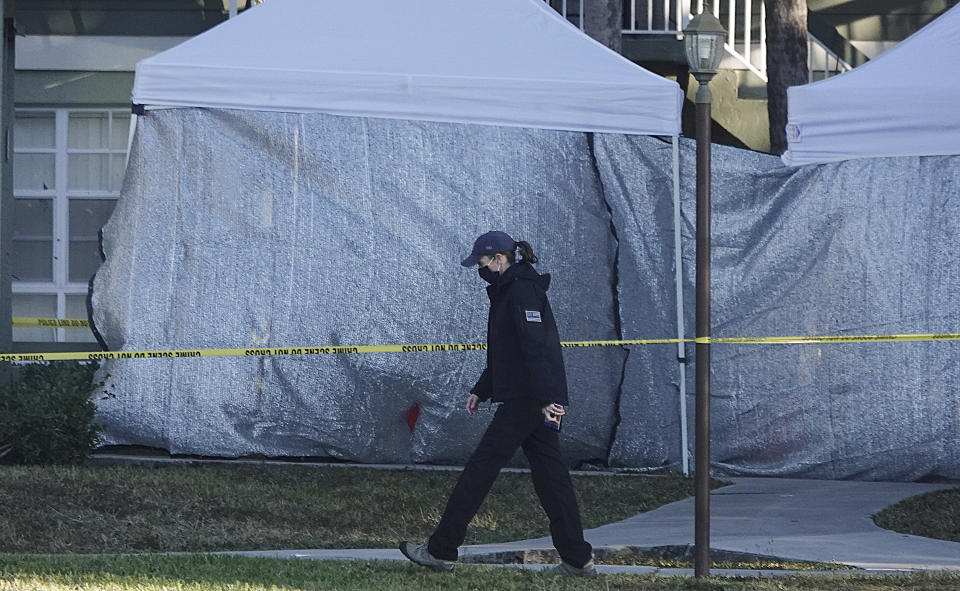 Law enforcement personnel continue to work at an apartment complex the day after a deadly shooting in Sunrise, Fla., Wednesday, Feb. 3, 2021. Several FBI agents were killed and others were wounded while trying to serve a search warrant on a child pornography suspect in Florida. FBI authorities say the suspect also died. (Joe Cavaretta/South Florida Sun-Sentinel via AP)