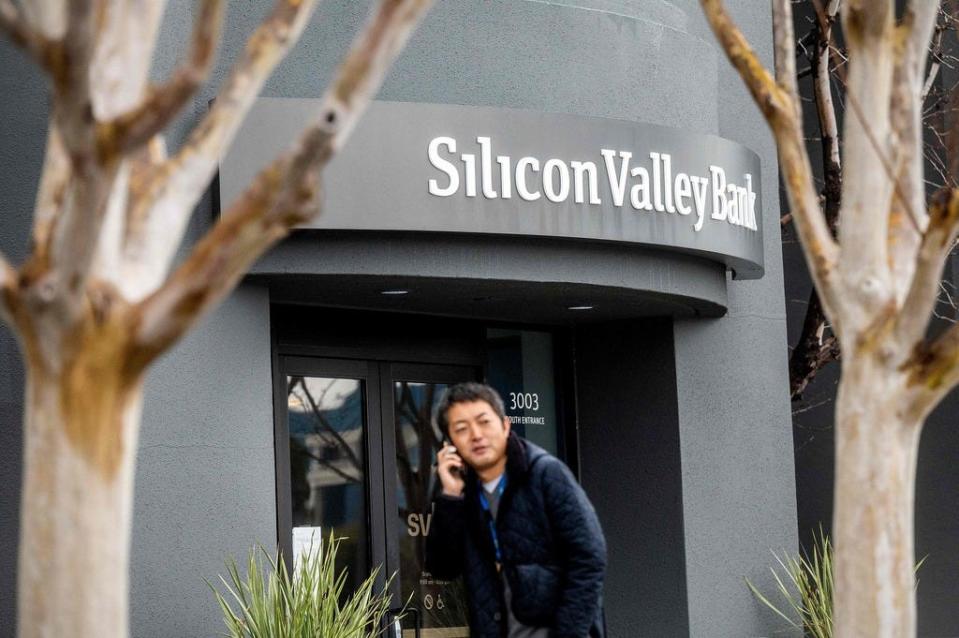 A pedestrian speaks on a mobile telephone as he walks past Silicon Valley Banks headquarters in Santa Clara, California on March 10, 2023. - US authorities swooped in and seized the assets of SVB, a key lender to US startups since the 1980s, after a run on deposits made it no longer tenable for the medium-sized bank to stay afloat on its own.