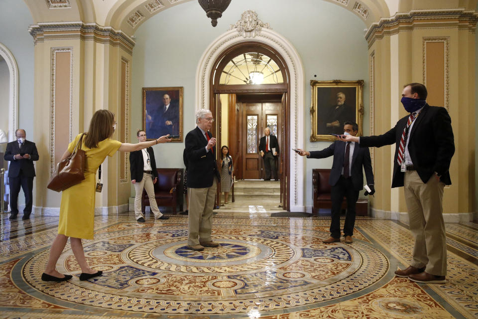 Senate Majority Leader Mitch McConnell of Ky., center, speaks with reporters outside the Senate chamber on Capitol Hill in Washington, Thursday, April 9, 2020. Senate Democrats on Thursday stalled President Donald Trump's request for $250 billion to supplement a "paycheck protection" program for businesses crippled by the coronavirus outbreak, demanding protections for minority-owned businesses and money for health care providers and state and local governments. (AP Photo/Patrick Semansky)