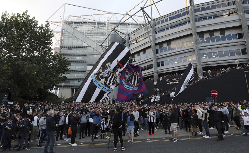 Newcastle United supporters celebrate outside St. James' Park in Newcastle Upon Tyne, England Thursday Oct. 7, 2021. English Premier League club Newcastle has been sold to Saudi Arabia’s sovereign wealth fund after a protracted takeover and legal fight involving concerns about piracy and rights abuses in the kingdom. (AP Photo/Scott Heppell)