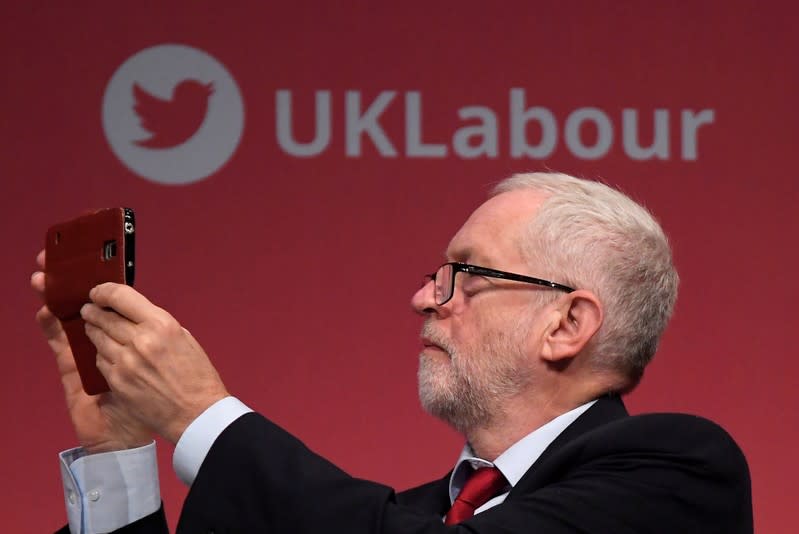 FILE PHOTO: Britain's opposition Labour Party leader Corbyn uses his smart phone whilst listening to speeches at the Labour Party Conference in Brighton, Britain