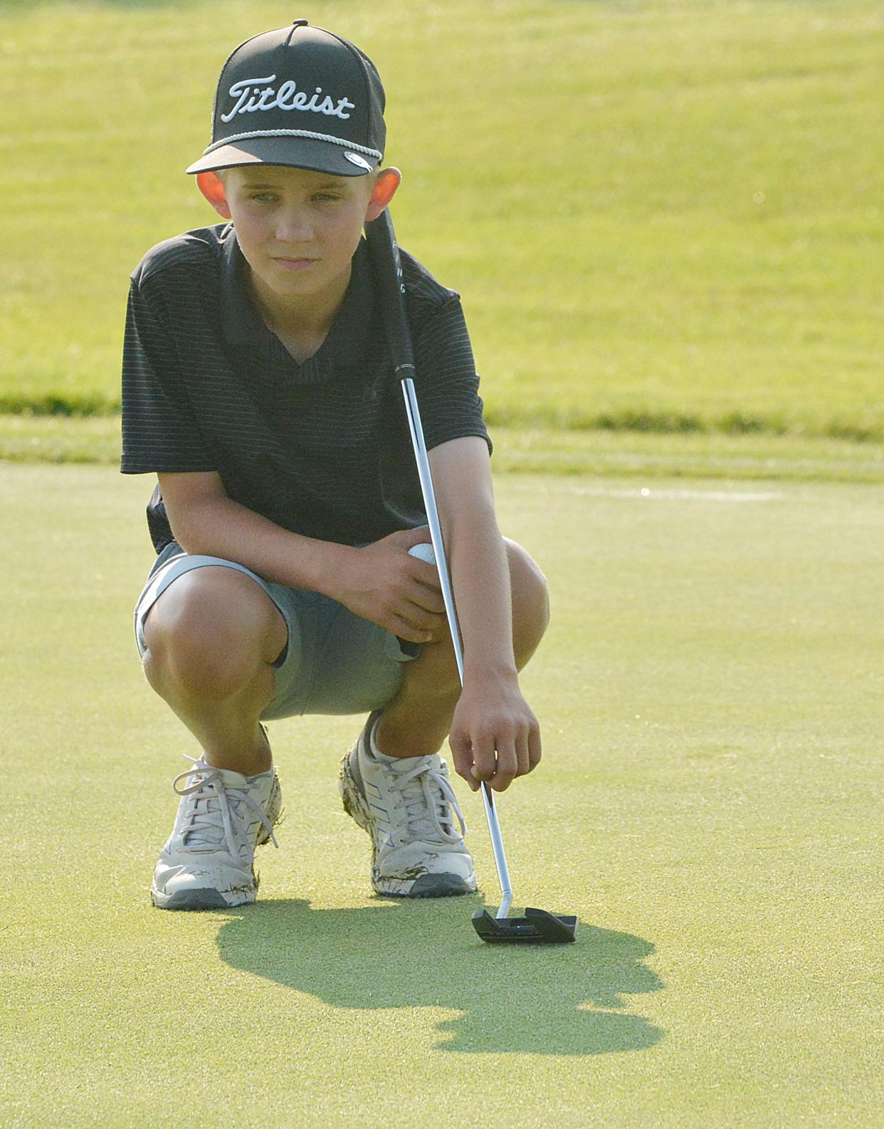 Brayden Liebl of Aberdeen (10-11 boys) studies a putt on No. 4 Blue during the South Dakota Golf Association Junior Tour stop on Tuesday, July 9, 2024 at Cattail Crossing Golf Course in Watertown.