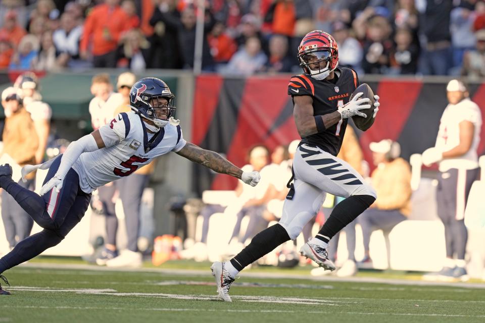 Cincinnati Bengals wide receiver Ja'Marr Chase (1) looks back at Houston Texans safety Jalen Pitre (5) while making a catch and run for a 64-yard touchdown during the second half of an NFL football game Sunday, Nov. 12, 2023, in Cincinnati. (AP Photo/Carolyn Kaster)