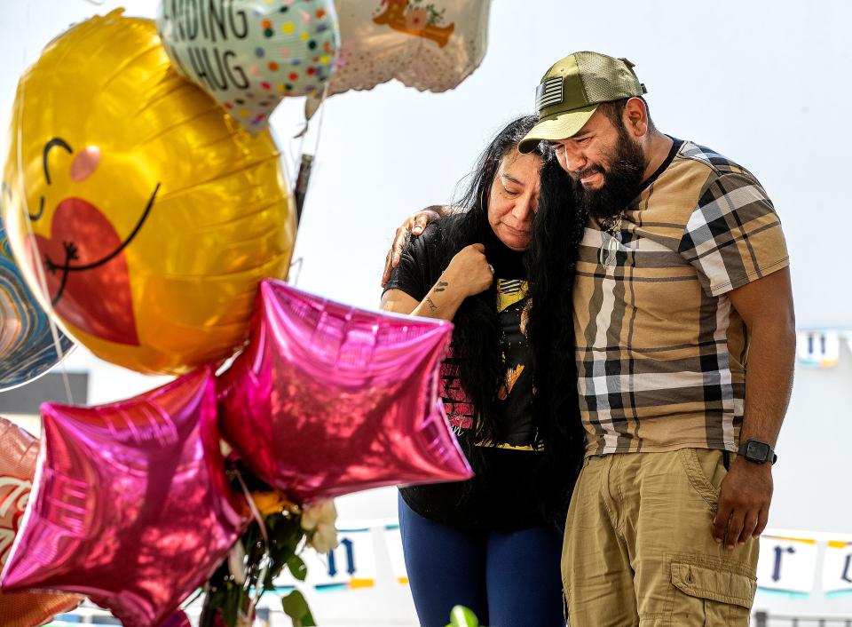 Alicia Pocopa and Mauricio Pocopa, older siblings of Yahorany "Nani" Popoca, show their grief Tuesday while visiting a makeshift memorial in the parking lot of La Fiesta Mexicana Restaurant in Haines City. Family members say that law enforcement could have done more to protect Nani against violent threats from her estranged romantic partner.