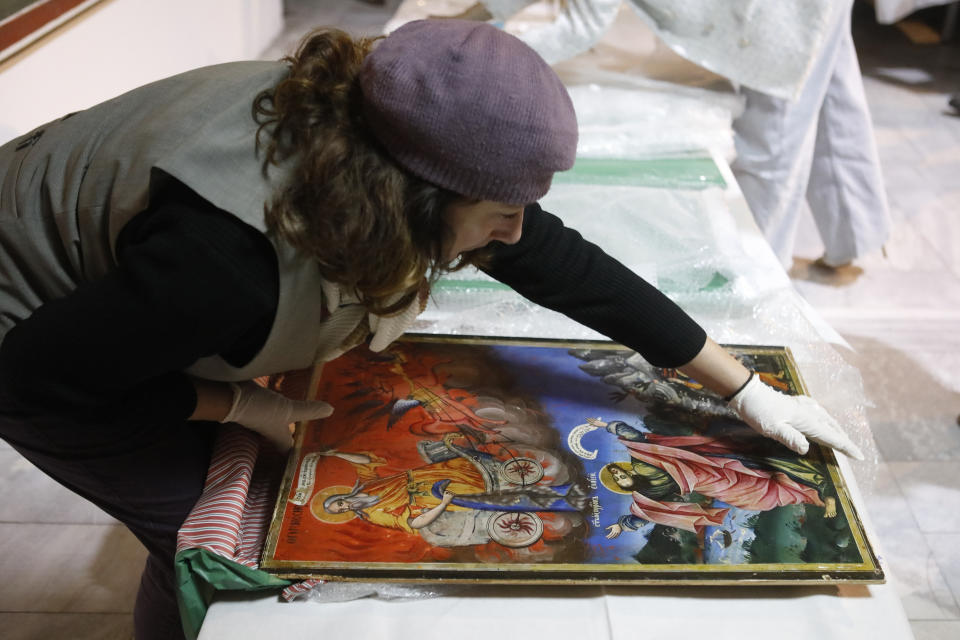 Museum worker unpacks an icon returned from Albania at the National museum in Skopje, North Macedonia, late Friday, Dec. 15, 2023. Albania on Friday returned 20 icons to neighboring North Macedonia that were stolen a decade ago. (AP Photo/Boris Grdanoski)