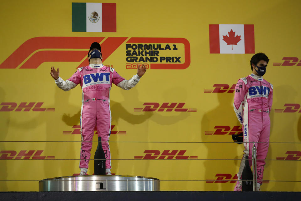 Racing Point's Mexican driver Sergio Perez (L) celebrates on the podium after winning the Sakhir Formula One Grand Prix at the Bahrain International Circuit in the city of Sakhir on December 6, 2020. - Mexican Sergio Perez claimed his maiden Formula One victory in a dramatic Sakhir Grand Prix in Bahrain on Sunday. The Racing Point driver, 30, won for the first time in his 194th race. (Photo by Bryn Lennon / POOL / AFP) (Photo by BRYN LENNON/POOL/AFP via Getty Images)