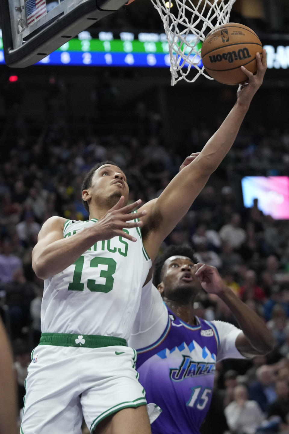 Boston Celtics guard Malcolm Brogdon (13) goes to the basket as Utah Jazz center Damian Jones (15) defends during the first half of an NBA basketball game Saturday, March 18, 2023, in Salt Lake City. (AP Photo/Rick Bowmer)