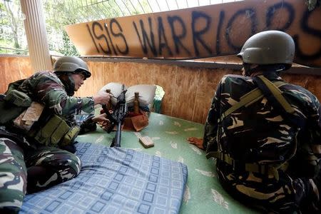 Filipino soldiers lie on a mattress at their combat position in a house as government troops continue their assault against insurgents from the Maute group in Marawi city, Philippines July 1, 2017. REUTERS/Jorge Silva