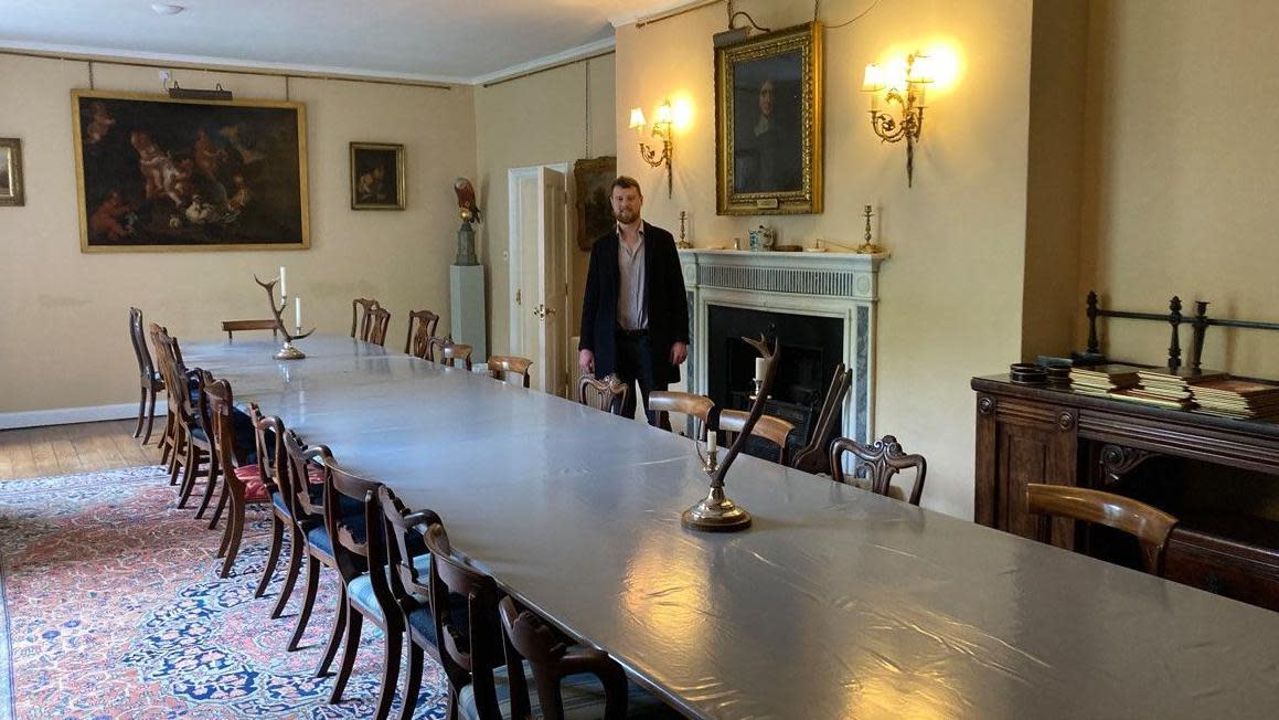 Blyth Hall, with William Dugdale standing by the table