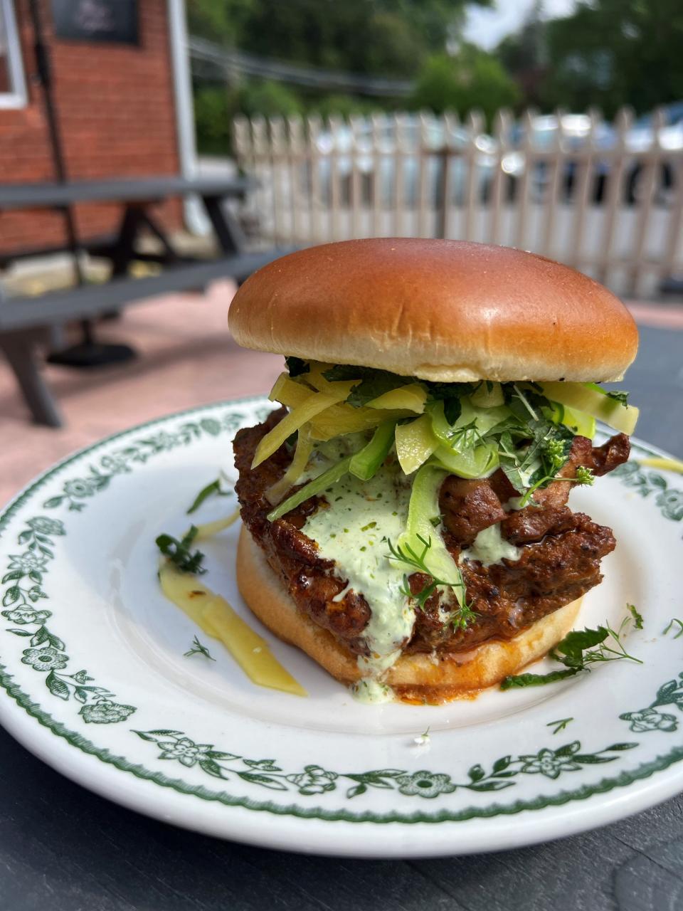 Regina's Aji Verde chicken thigh sandwich topped with an Armenian pale cucumber, mango, jalapeño and lime slaw.