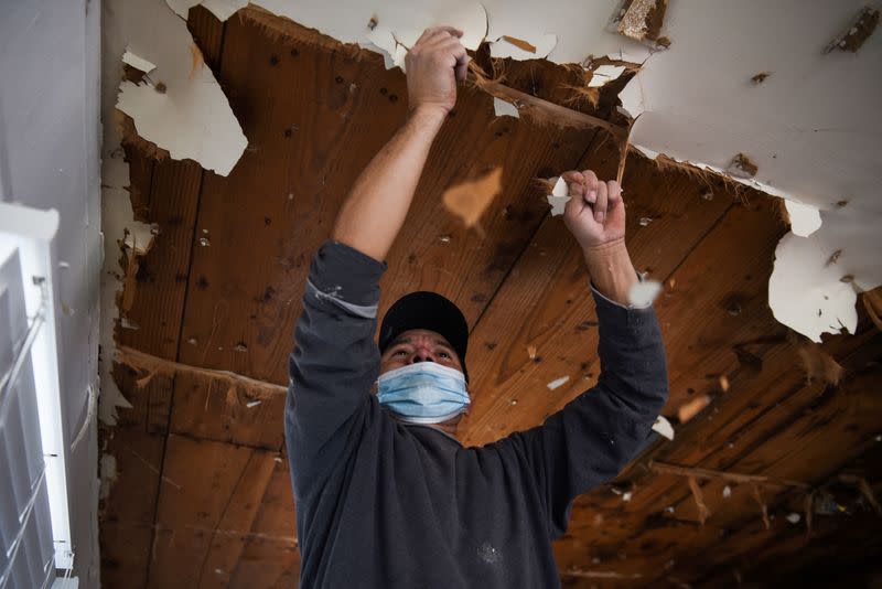 FILE PHOTO: A contractor removes material from a ceiling in a recently-purchased home in Houston