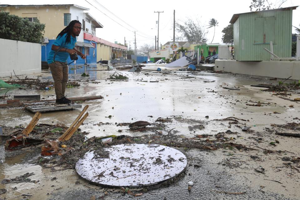 A man walks along a debris-filled street in the Hastings neighborhood after Hurricane Beryl passed in Bridgetown, Barbados Monday