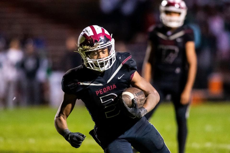 Peoria High's Eddie Clark runs the ball during Thursday's game in Peoria Stadium on Oct. 21, 2021. Peoria High pulled ahead in the final quarter and won 40-35.
