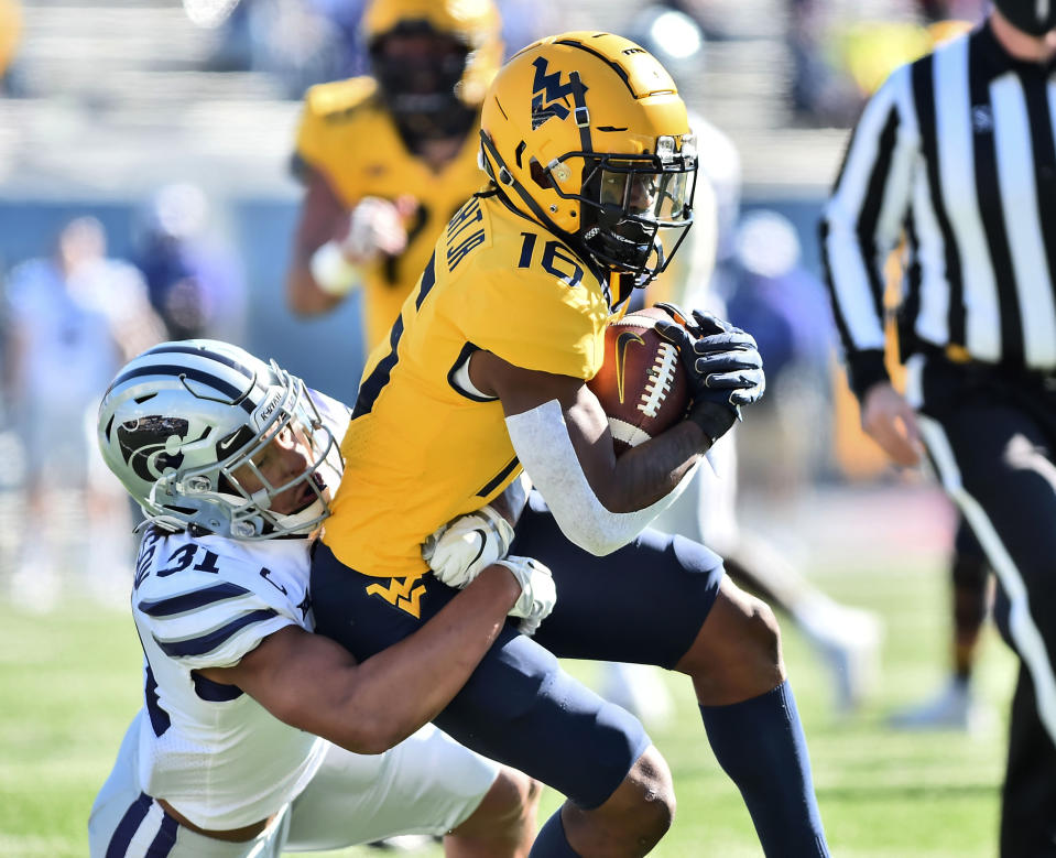 West Virginia wide receiver Winston Wright Jr. (16) is tackled after a catch by Kansas State defensive back Jahron McPherson (31) during an NCAA college football game Saturday, Oct. 31, 2020, in Morgantown, W.Va. (William Wotring/The Dominion-Post via AP)