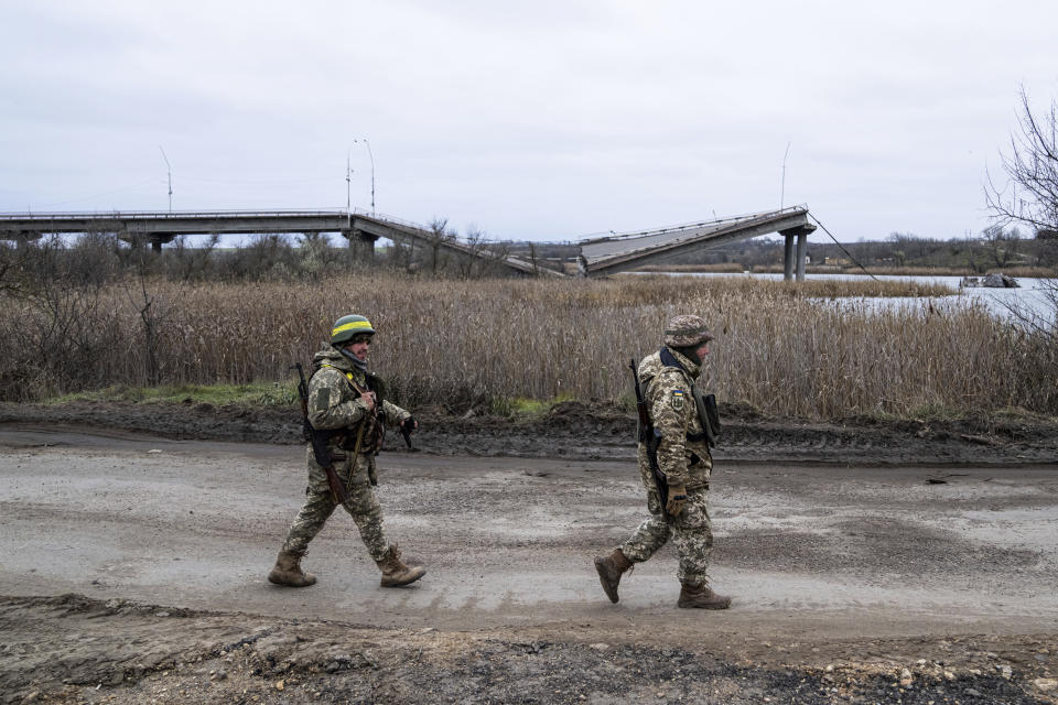 Ukrainian servicemen walk near a destroyed bridge across the Inhulets river in Kherson region, Ukraine, Saturday, Dec. 3, 2022. (AP Photo/Evgeniy Maloletka)