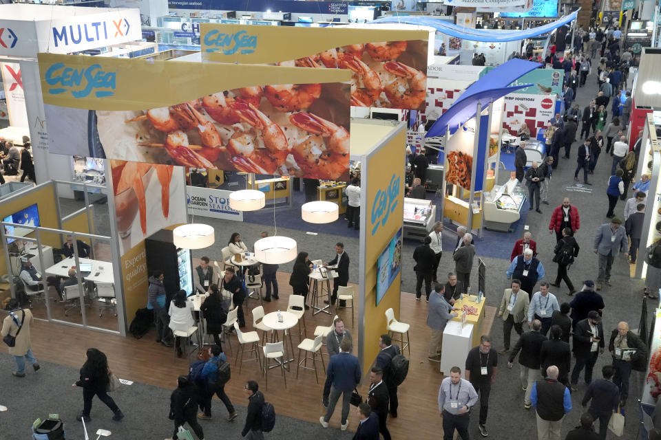 Signs displaying shrimp appear on an exhibit booth, left, for CenSea, a frozen seafood importer, at the North American Seafood Expo, Monday, March 11, 2024, in Boston. U.S. trade records show the Indian company Nekkanti Sea Foods shipped 726 U.S. tons of farmed shrimp from India to the U.S. in the past year, to major American seafood distributors including AJC International Inc., Eastern Fish, CenSea, Jetro Cash & Carry Enterprises, King & Prince Seafood, Red Chamber Co. and Rich Products Corp. Those companies, in turn, sell Indian shrimp under popular brand names including Costar, Good & Gather, Great Value and Mrs. Friday’s at supermarkets, box stores and restaurants across the U.S. (AP Photo/Steven Senne)