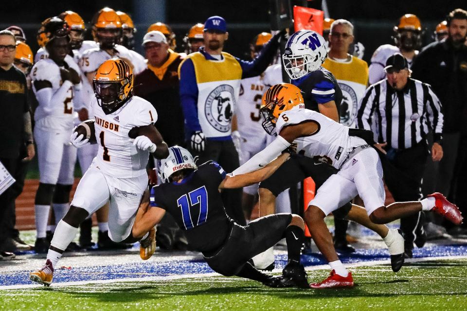 Davison running back Jay'len Flowers (1) runs against  Walled Lake Western defensive back Jaxon Lippert (17) during the first half at Walled Lake Western High School in Commerce Township on Friday, Sept. 30, 2022.