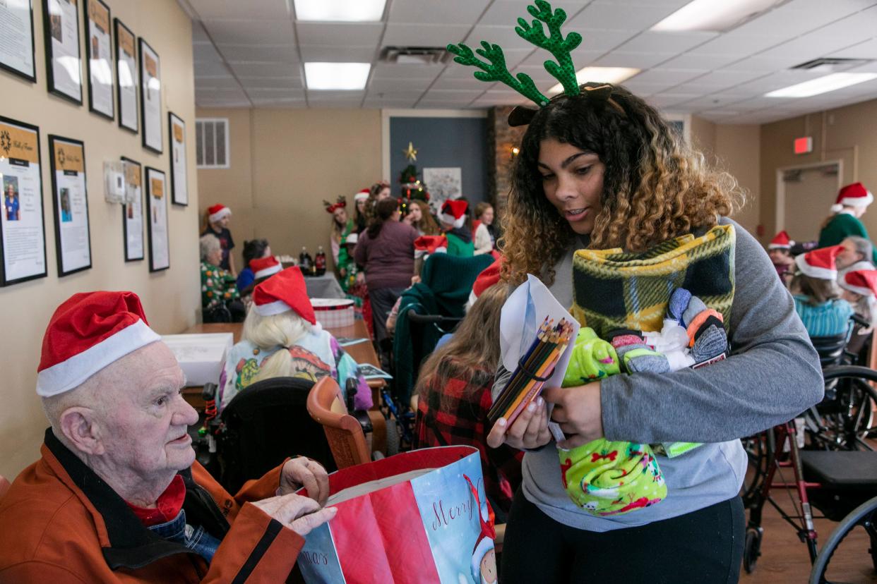 Taraji Fultz, of Laurelville, goes through some of the items in the gift bag she gave Don Dodd, 88 of Chillicothe, as she and other students from Zane Trace Middle School gave gifts and sang Christmas carols for the residents of Signature HealthCARE of Chillicothe on December 20, 2023, in Chillicothe, Ohio.