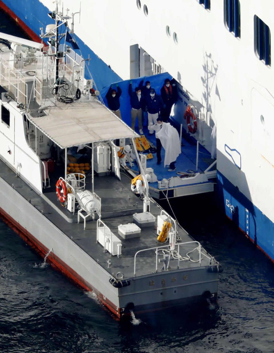 Pictured are Diamond Cruise passengers being transferred from the ship to a patrol ship after people tested positive for coronavirus.