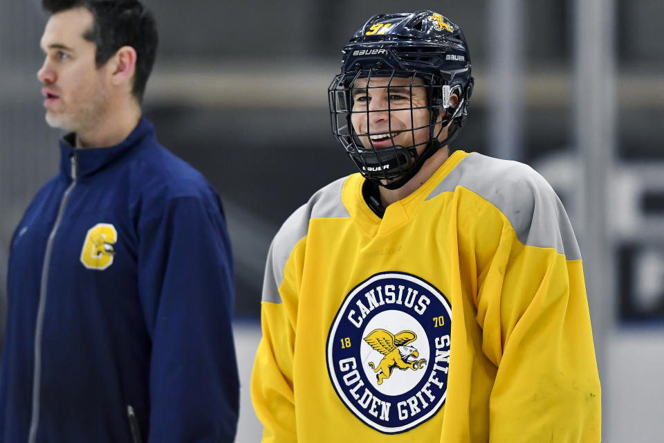 Canisius left wing Alton McDermott, right, reacts during an NCAA college hockey practice in Buffalo, N.Y., Thursday, Jan. 26, 2023. McDermott's grandfather, former NHLer Paul Henderson, scored the decisive goal in clinching Canada its Summit Series win over Russia some 50 years ago and will celebrate his 80th birthday with a ceremonial puck drop before Cansius' game against Niagara. (AP Photo/Adrian Kraus)