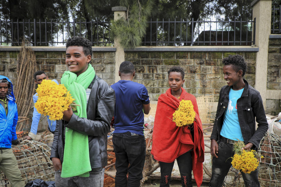 Young men sell bunches of flowers at Sholla Market, the day before the Ethiopian New Year, in Addis Ababa, Ethiopia Saturday, Sept. 10, 2022. Once home to one of Africa's fastest growing economies, Ethiopia is struggling as the war in its Tigray region has reignited and Ethiopians are experiencing the highest inflation in a decade, foreign exchange restrictions and mounting debt amid reports of massive government spending on the war effort. (AP Photo)