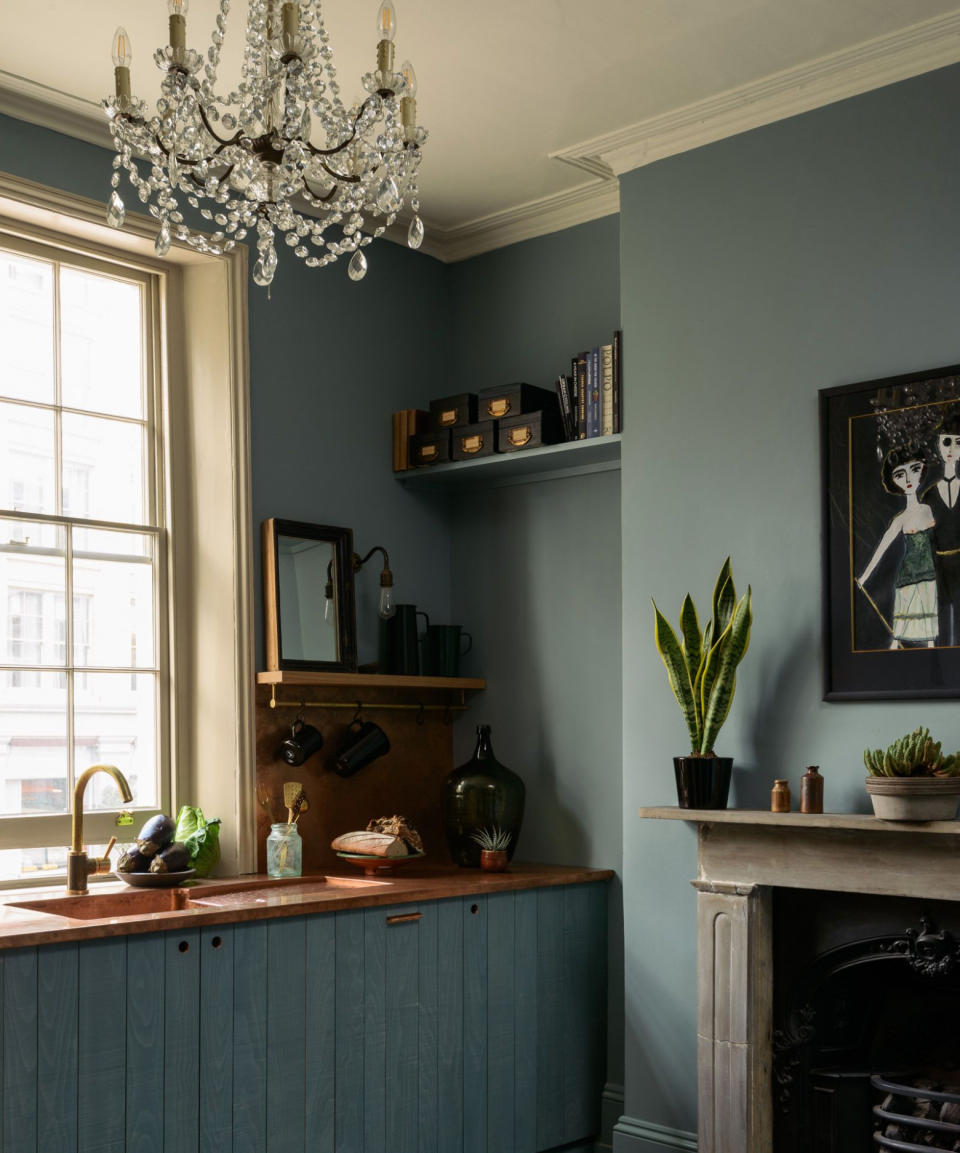 rustic blue kitchen with blue walls and a chandelier