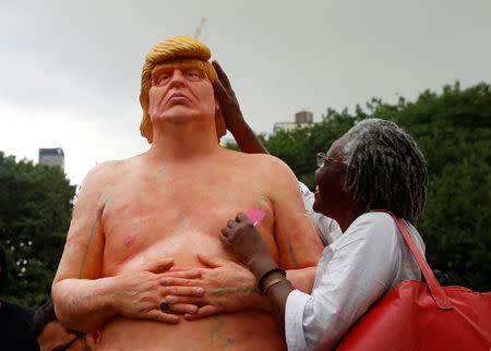 A woman touches a naked statue of U.S. Republican presidential nominee Donald Trump that was left in Union Square Park in New York City, U.S. August 18, 2016. REUTERS/Brendan McDermid