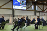 Police officers and others sit in a waiting zone after receiving their COVID-19 vaccine at the Brussels Expo center in Brussels, Thursday, March 4, 2021. The Expo is one of the largest vaccination centers in Belgium. (AP Photo/Olivier Matthys)