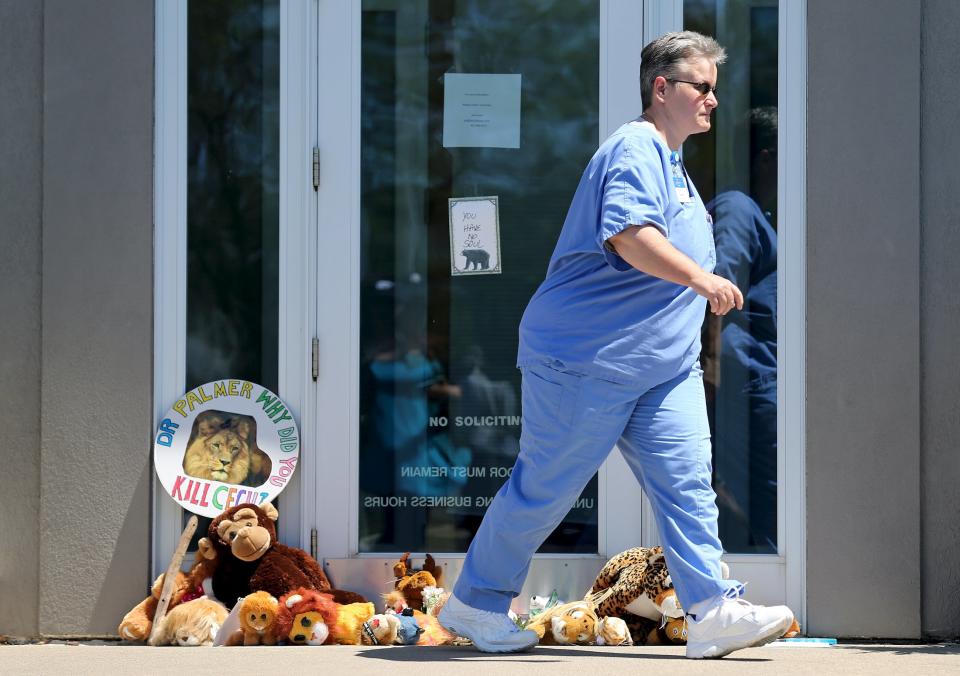 A woman leaves a note taped to the doorway of River Bluff Dental clinic in protest against the killing of a famous lion in Zimbabwe, in Bloomington, Minnesota July 29, 2015. A Zimbabwean court on Wednesday charged a professional local hunter Theo Bronkhorst with failing to prevent an American from unlawfully killing 'Cecil', the southern African country's best-known lion. (REUTERS/Eric Miller)