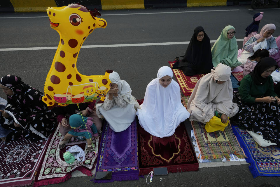 Muslims attend for Eid al-Adha prayer on a street in Jakarta, Indonesia, Monday, June 17, 2024. Muslims around the world celebrate Eid al-Adha by sacrificing animals to commemorate the prophet Ibrahim's faith in being willing to sacrifice his son. (AP Photo/Achmad Ibrahim)