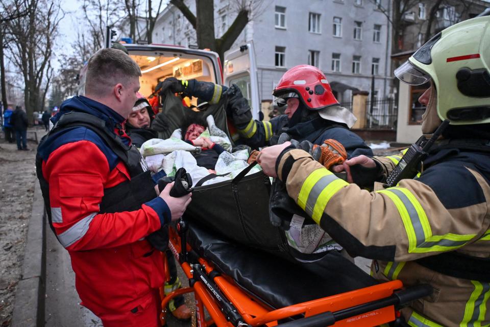 Ukrainian rescuers evacuate a wounded woman from a damaged residential building in the centre of Kharkiv after a missile strike on January 2, 2024, amid the Russian invasion in Ukraine.