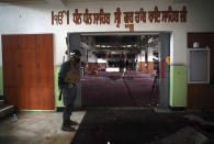 FILE- in this Wednesday, March 25, 2020, photo, a policeman stands guard at the entrance to a Sikh house of worship as journalists film the aftermath of an attack in Kabul, Afghanistan. Pakistan asked neighbor Afghanistan to extradite Aslam Farooqi, a leader of the local Islamic State affiliate, who was arrested in an Afghan intelligence operation in southern Afghanistan earlier this month. (AP Photo/Rahmat Gul, file)