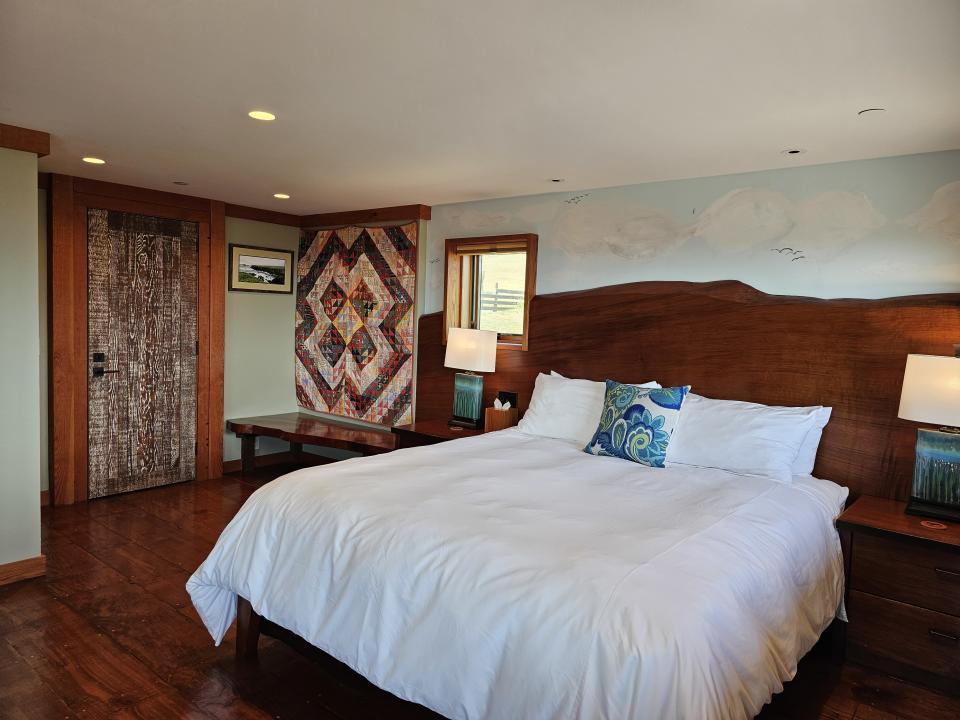 A beautiful bedroom at the Inn at Newport Ranch featuring custom art and carvings