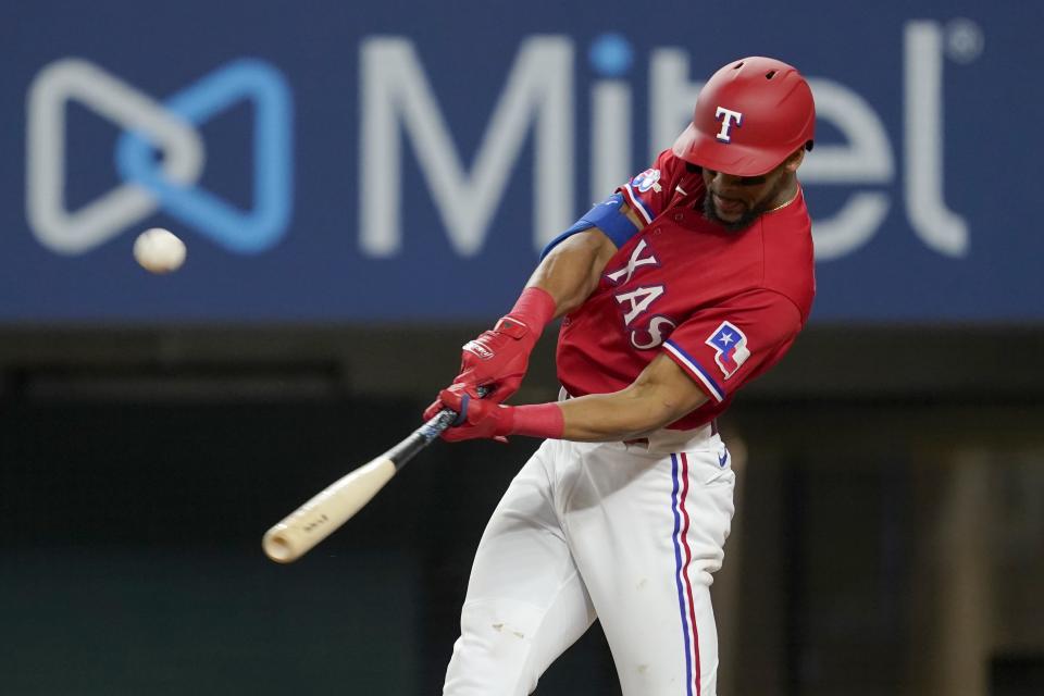 Texas Rangers' Leody Taveras follows through on a sacrifice fly that scored Jonah Heim in the fifth inning of a baseball game against the Minnesota Twins, Friday, July 8, 2022, in Arlington, Texas. (AP Photo/Tony Gutierrez)